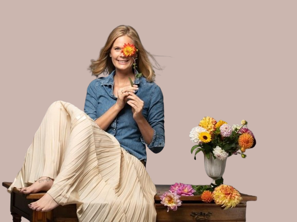 Bild Jennifer Schweizer mit Blume mit hellbraunem Hintergrund